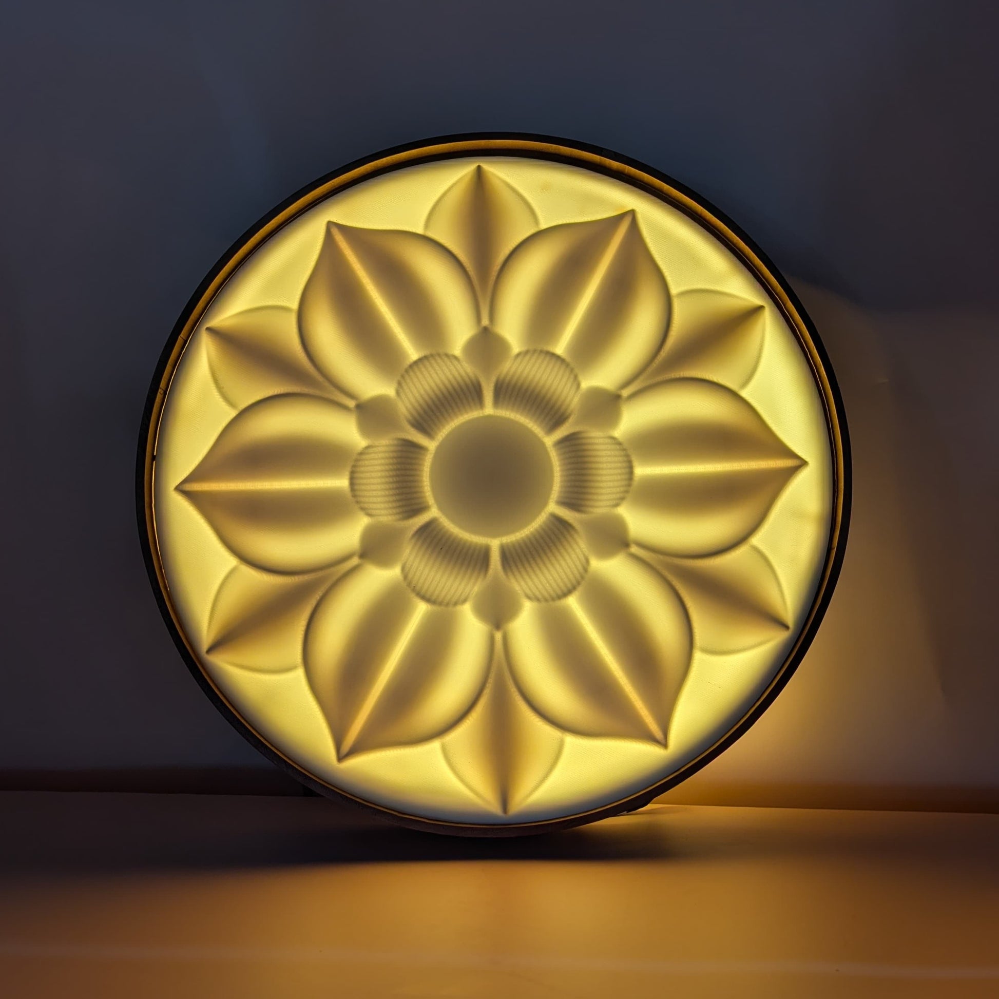 A circular wall light with a radiant floral mandala design, featuring layered petals and a warm golden glow.